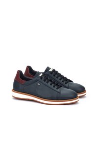 Zapatillas de cuero con parte superior en un oscuro navy, acentos en burdeos en el talón y cordones negros. Presentan una media suela blanca con un detalle de franja marrón.