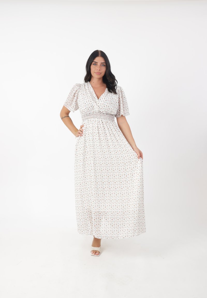 Abito maxi in un leggero tessuto bianco con piccoli motivi floreali in colori pastello. Vita arricciata e maniche a sbuffo corte.