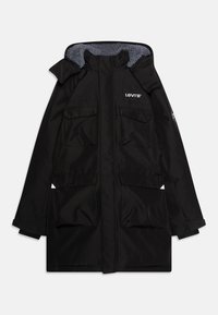 Zwarte parka jas met een grijs gevoerde capuchon, twee grote voorzakken en een logo op de borst. Voorzien van lange mouwen en een rechte snit.