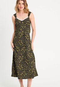 Blumenmusterkleid in Schwarz mit gelben Akzenten. Verfügt über einen V-Ausschnitt mit weißer Spitzenverzierung und breiten Trägern. Fließendes, knielanges Design.