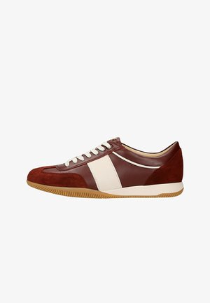 Rode en witte sneaker met een bovenwerk van suede en leer, voorzien van een rubberen zool, ronde neus en contrasterende zijstreep; vetersluiting.