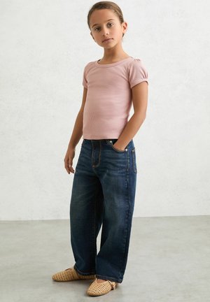 Lichtroze geribd t-shirt, wijde blauwe spijkerbroek en geweven beige sandalen. Casual outfit met korte mouwen en een eenvoudig ontwerp.