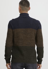 Maglione lavorato a maglia con colletto alto, caratterizzato da un motivo a blocchi di colore in blu scuro, marrone e verde, tessuto testurizzato e polsini a coste.