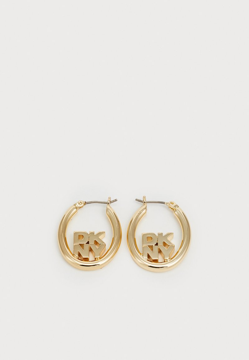 Brincos em forma de argola em ouro com um destacado logotipo "DKNY" em fonte bold e em bloco. Acabamento metálico elegante com uma textura polida.