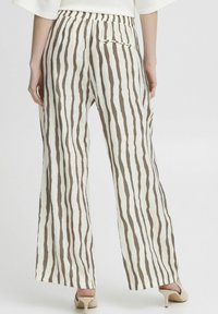 Lightweight, cream-colored pants with vertical brown stripes, featuring an elastic waistband and a single back pocket.