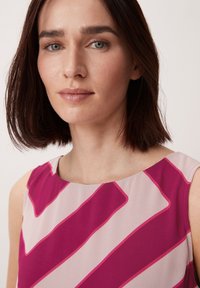 Ärmelloses Kleid mit rundem Ausschnitt, das pinke und hellpinkfarbene diagonale Streifen auf einem glatten Stoff zeigt. Sauberer Schnitt ohne Verzierungen.