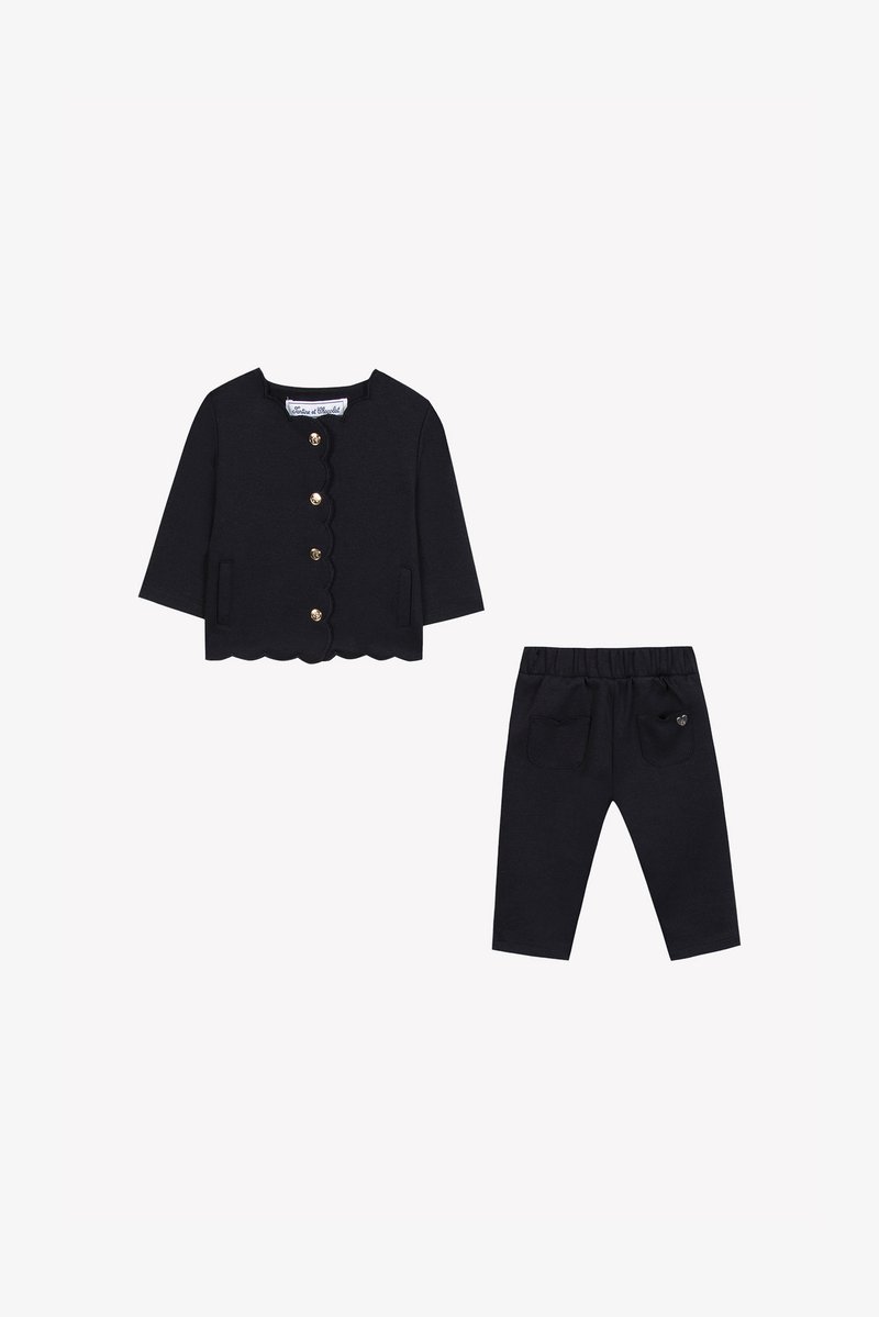 Ναυτικό βαμβακερό σετ δύο κομματιών που περιλαμβάνει ζακέτα με περιθώριο σε κοφτό σχέδιο, χρυσά κουμπιά και τσέπες, συνδυασμένη με παντελόνι παρόμοιου σχεδιασμού που διαθέτει πλάγιες τσέπες.
