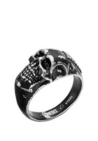 Skull-shaped ring made of black stainless steel with a brushed finish, featuring detailed bone structure and worn texture accents.