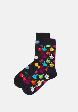 Deux paires de chaussettes en coton : l'une noire avec des motifs de fruits colorés, l'autre marine avec des icônes de pouces levés multicolores.