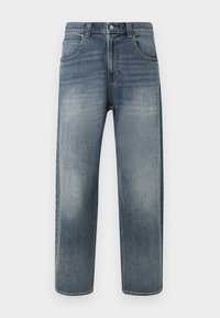 Svijetloplave traperice ravnog kroja s pet džepova, patentnim zatvaračem i diskretnim blijeđenjem na nogavicama. Završene ukrasnim šavovima.