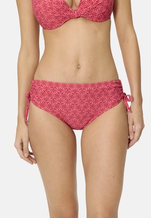Mujer con braguitas de bikini de estampado rosa con lazos laterales y parte superior de bikini con aro a juego, mostrada desde el abdomen hasta la parte superior de los muslos.