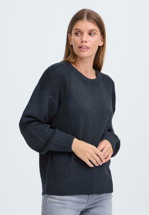 Pull en maille sombre avec des poignets côtelés et des panneaux latéraux présentant un motif texturé, un col rond et une coupe légèrement décontractée.