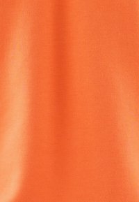 Oranje stof met een zachte textuur, met een gladde, matte afwerking en een egale kleur zonder zichtbare patronen of accenten.