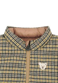 Karierter Blazer in Braun-, Gelb- und Schwarztönen, mit hohem Kragen, beiger Fütterung und Bärenlogo in der Nähe des Reißverschlusses.