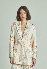 Blazer bordado floral en beige claro, con patrones multicolores, solapas de pico, dos bolsillos y un ajuste relajado.