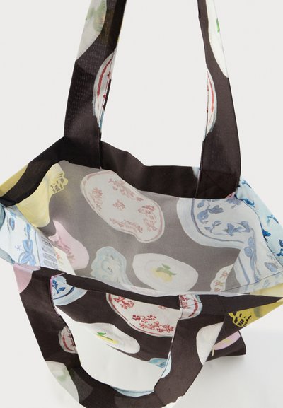 Επαναχρησιμοποιήσιμη τσάντα ώμου με μαύρες λαβές, διακοσμημένη με πολύχρωμο λουλουδένιο και φρουτώδες σχέδιο σε ανοιχτό φόντο.