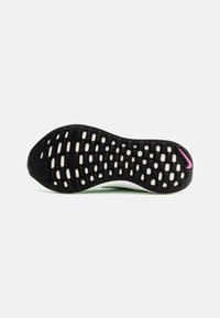 Semelle de chaussure de course texturée noire et blanche avec des motifs de grip rectangulaires et un petit logo Swoosh rose près de l'avant-pied.