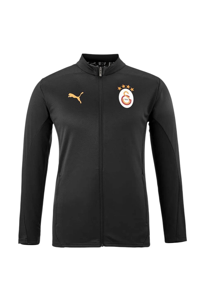 Schwarze Sportjacke aus glattem Stoff, mit hohem Kragen, durchgehendem Reißverschluss, Puma-Logo in Gold und einem Mannschaftswappen mit Sternen auf der Brust.