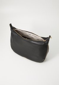 Black leather clutch bag with gold zipper. Interior features a patterned fabric lining. Minimalist, sleek design with a rounded shape.