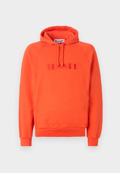 Oranžs kapucis džemperis ar ribotām apakšmalām un piedurknēm, ar iešūtu "SUNNEI" logo atbilstošā krāsā uz krūtīm. Izgatavots no mīksta auduma.