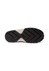 Svart skosula med djupt zigzag-mönster och en beige triangular sektion nära mitten för grepp och stöd.