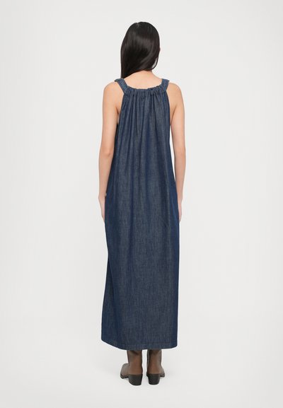 Rochie lungă din denim, cu decolteu adunat, design fără mâneci, într-o nuanță de albastru închis, siluetă fluidă și hem lung până la gleznă.