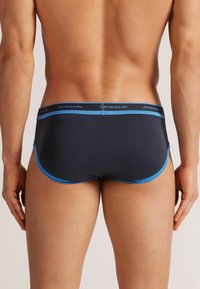 Herren-Boxershorts in Dunkelblau mit hellblauen Akzenten. Sie verfügen über einen elastischen Bund mit Logo, glattem Stoff und eine enganliegende Passform.