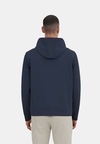 Felpa con cappuccio blu navy realizzata in tessuto morbido, con una vestibilità rilassata, polsini a costine e un design semplice senza loghi visibili.