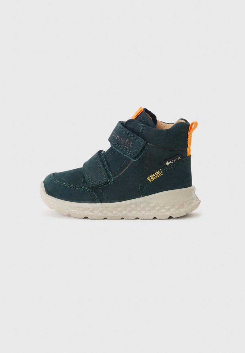 Dunkelblaue High-Top-Schuhe aus Wildleder mit zwei Klettverschlüssen, einer strukturierten hellen Sohle und einem orangefarbenen Akzent hinten.