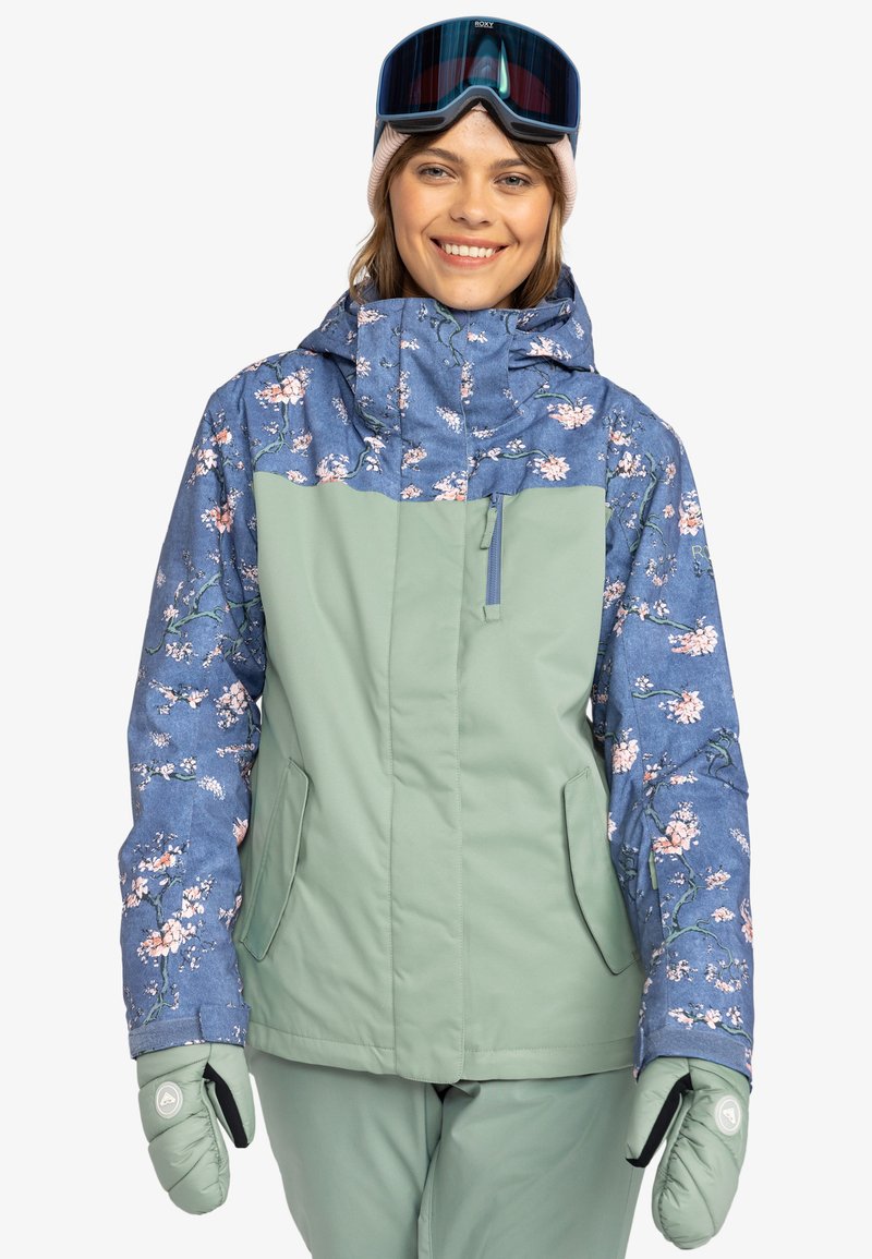 Women’s snowboard jacket featuring a blue floral patterned upper and a solid light green lower. Includes a hood and front pockets.