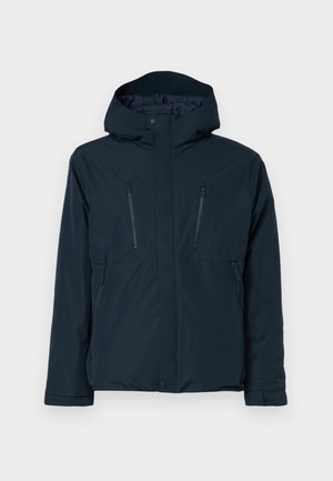 Mørk marineblå vanntett jakke med hette, med to glidelås brystlommer og frontlukking. Glatt tekstur med minimale detaljer.