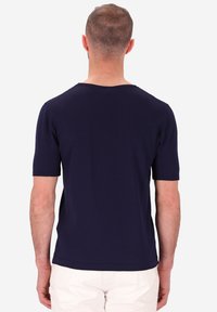 T-shirt a maniche corte blu navy, con scollatura rotonda e una morbida texture in cotone, dal taglio semplice e classico e senza loghi visibili.