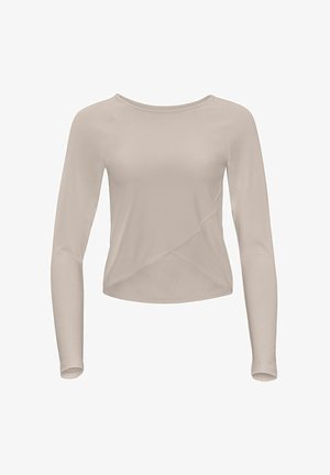 Top beige a maniche lunghe realizzato in tessuto morbido ed elastico. Presenta una scollatura tonda e un taglio asimmetrico con un effetto avvolgente in vita.
