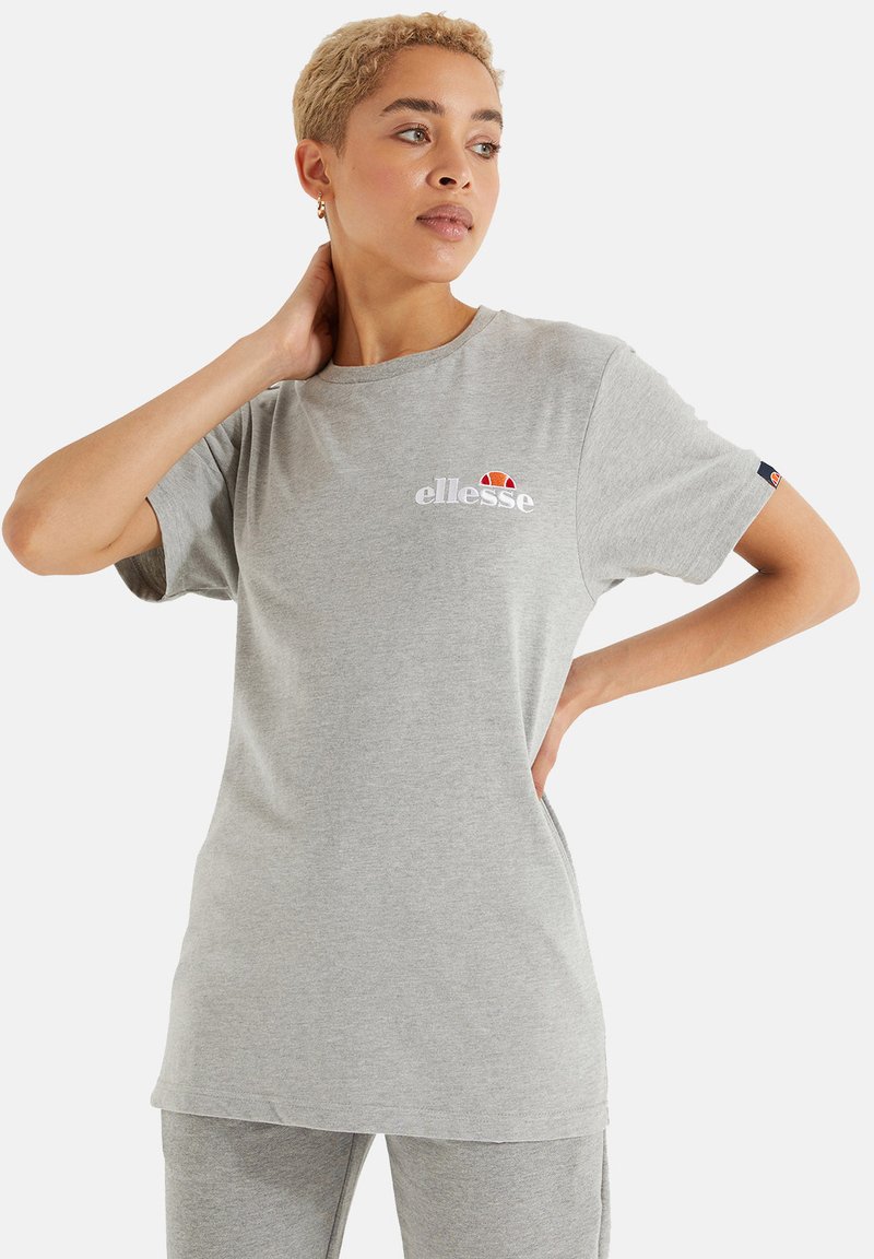 T-shirt en coton gris à manches courtes, décolleté rond et coupe allongée. Présente un logo "ellesse" blanc et un accent coloré au-dessus.