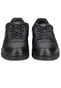 Black leather sneakers with rounded toes, flat laces, and textured rubber soles. Features subtle branding and stitched accents.