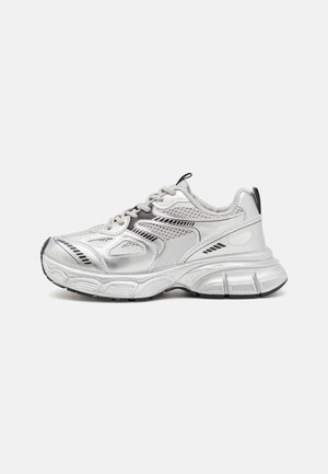 Sneaker chunky argento e bianco con dettagli neri, pannelli in mesh, suola spessa e texturizzata, e linguette di tiraggio su linguetta e tallone.