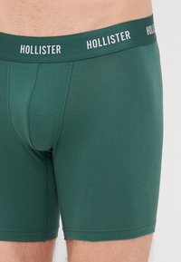 Boxeri dintr-un amestec de bumbac verde, cu o croială ajustată, talie elastică cu logo-ul "HOLLISTER" și o textură netedă.
