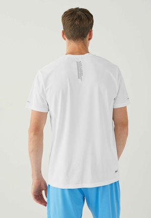 White athletic T-shirt with short sleeves, textured fabric, and printed accents on the upper back. Paired with blue shorts.