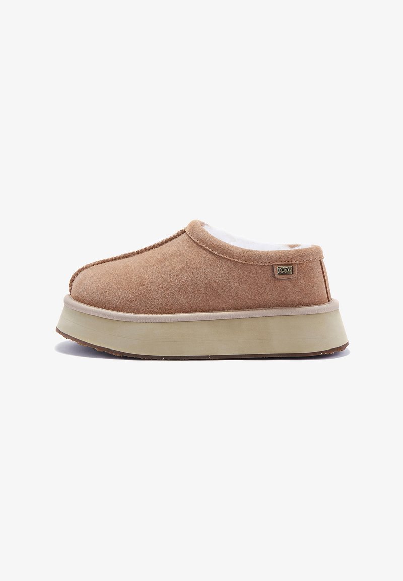 Tan slip-on topánka s hladkým semišovým zvrškom, mäkkou podšívkou a ľahkou gumovou podrážkou. Má jemnú značkovú etiketu na boku.