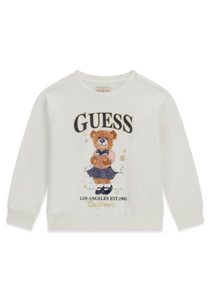Sweat-shirt blanc à manches longues avec un ours portant une jupe et tenant un livre, texte ""GUESS"" au-dessus et ""LOS ANGELES EST.1981 California"" en dessous.