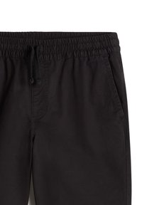 Zwarte elastische broek met trekkoord, voorzien van zijzakken en een zachte stoftextuur. Eenvoudig ontwerp zonder zichtbare patronen of accenten.