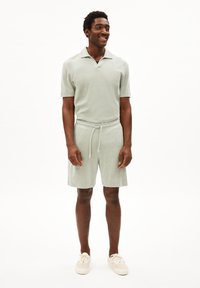 Lichtgroene, korte mouwen polo met een kraag, gecombineerd met bijpassende shorts. Beide hebben een zachte textuur, een slim-fit ontwerp en een trekkoord taille.