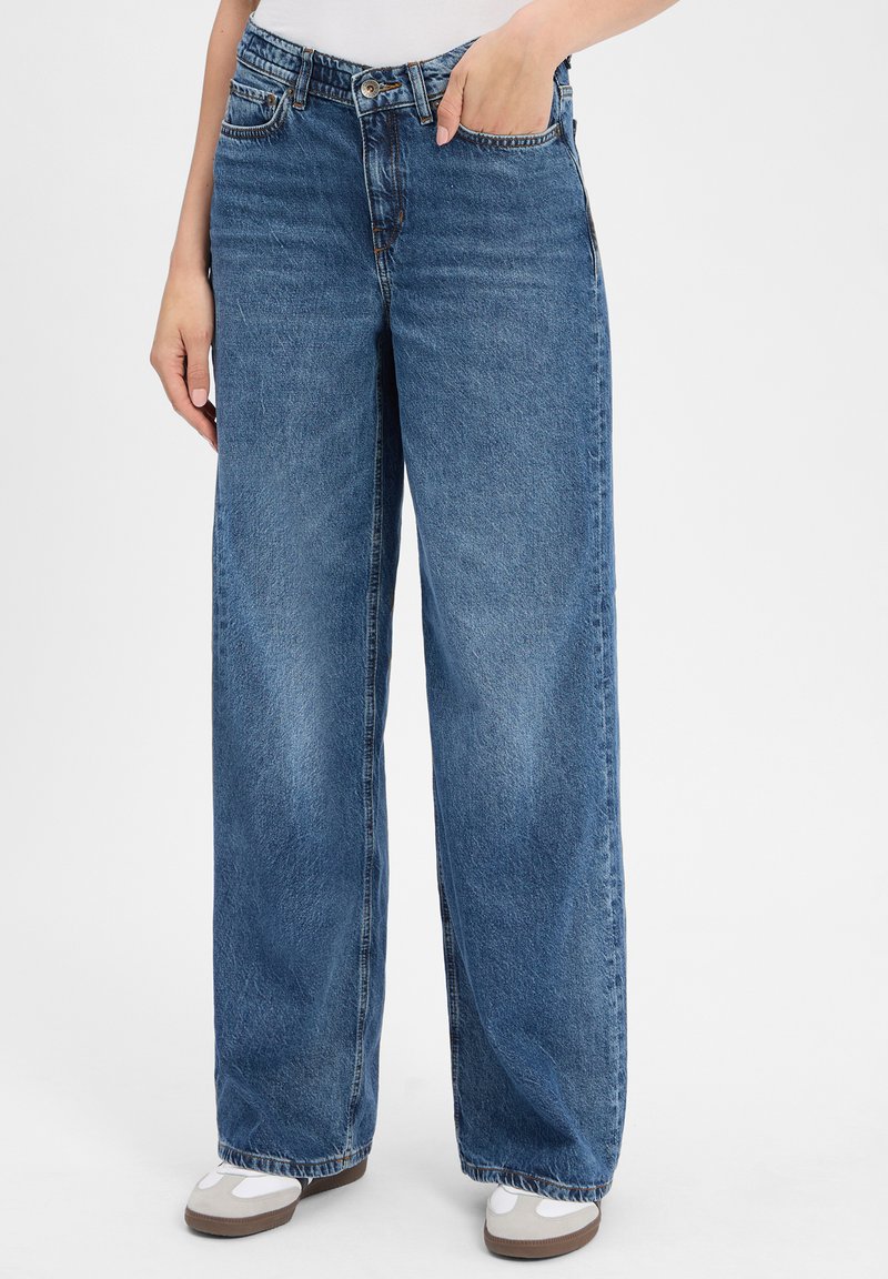 Lichte wijdvallende denim jeans in medium blauw met een vervaagde textuur, voorzien van vijf zakken, riemlussen en een knoopsluiting.