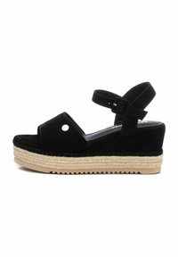 Sandalias de cuña de ante negro con una correa en el tobillo, plataforma de esparto texturizada y suela plana, que presenta un pequeño acento metálico.