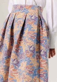 Rozenpatroon rok in blauwe, oranje en paarse tinten, met plooien en een zijrits, gemaakt van textuurstof.