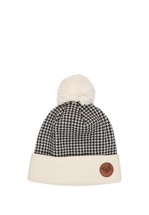 Black and white houndstooth knitted beanie with a cream cuff, cream pom-pom on top, and a small round leather logo patch on the cuff.
