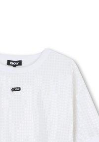 T-shirt blanc DKNY avec un motif de pois texturé, encolure ronde, et un petit patch logo noir en haut à gauche.