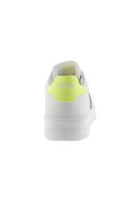 Witte sneaker met een gladde leren bovenkant, paarse accenten en een felgele hieltab. Heeft een gevoerde kraag en een logo op de achterkant.