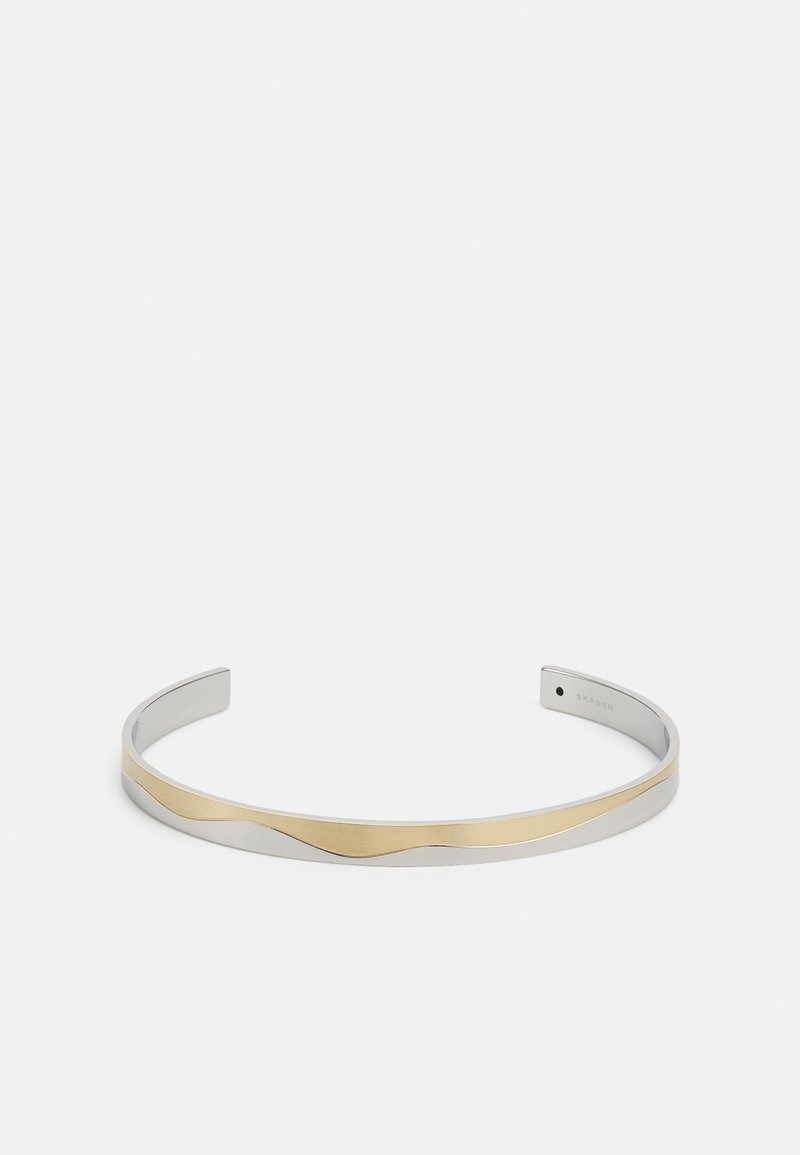 Bracelet jonc fin ouvert avec une base argentée lisse et une bande dorée ondulée autour du centre.