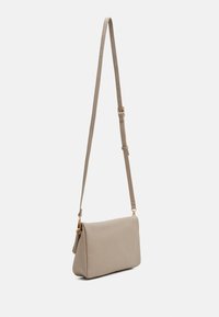 Borsa a tracolla beige realizzata in materiale sintetico testurizzato, con una sottile cintura regolabile e dettagli in metallo color oro.